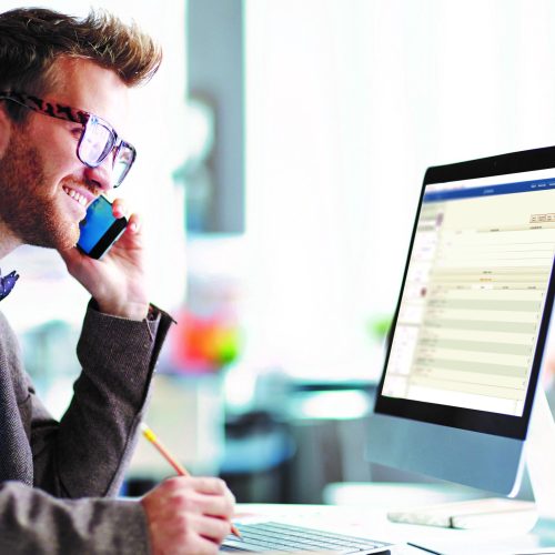 Businessman speaking on the phone and looking at computer screen with chart and diagrams